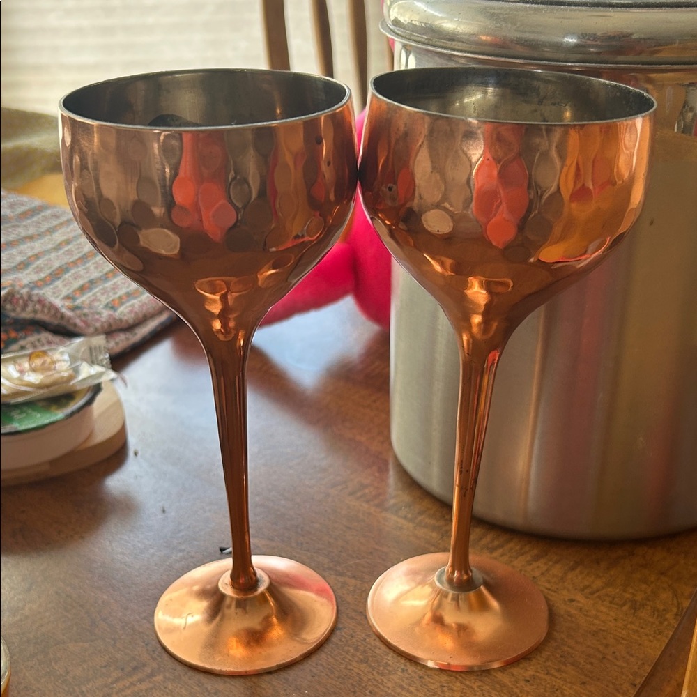 copper-finished goblet glasses, featuring a hammered exterior and long stems.